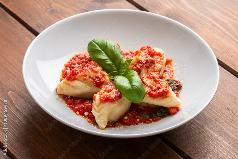 Culurgionis ripieni di patate, pecorino e menta e conditi con sugo, classica ricetta di pasta della cucina Sarda cibo italiano Culurgionis ripieni di patate, pecorino e menta e conditi con sugo, classica ricetta di pasta della cucina Sarda cibo italiano