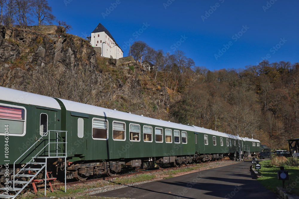 Obraz premium Historische Eisenbahnwaggons des Zughotels am Fuße des Schlosses Wolkenstein im Zschopautal, Wolkenstein, Erzgebirgskreis, Sachsen, Deutschland