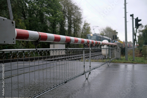 Regenfoto von Bahnschranke und herannahender Güterzug - Stockfoto