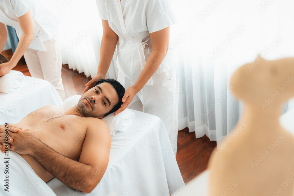 Obraz premium Caucasian couple enjoying relaxing anti-stress head massage and pampering facial beauty skin recreation leisure in dayspa modern light ambient at luxury resort or hotel spa salon. Quiescent