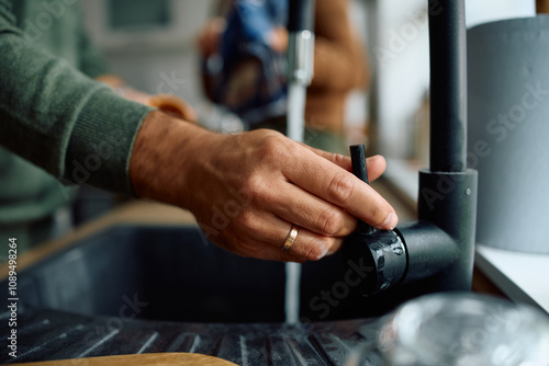 Close up of man doing  dishes in  kitchen.
