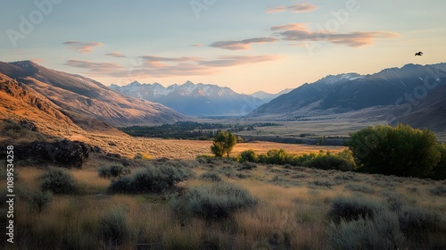 Stunning sunset over rugged mountains and open fields in a serene landscape.