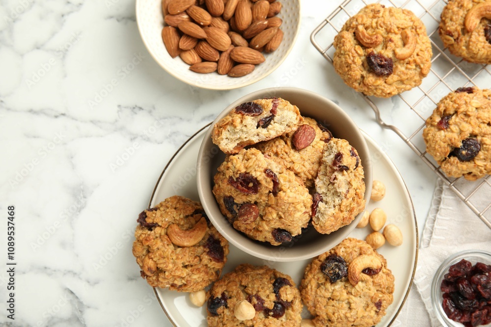Delicious oatmeal cookies with raisins and nuts on white marble table, flat lay Delicious oatmeal cookies with raisins and nuts on white marble table, flat lay