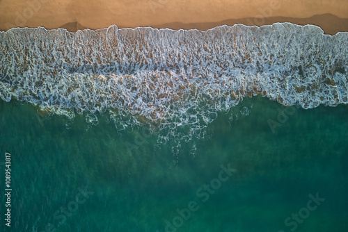 Top-down view of the ocean surf and the sand shore photo