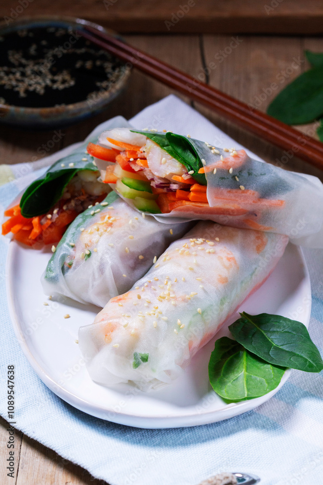 Summer or spring rolls with shrimp, vegetables and spinach, served with soy sauce and sesame. Traditional Vietnamese food.