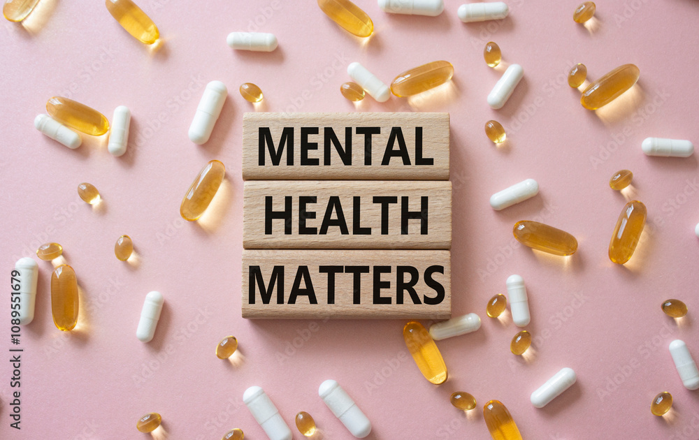 Fototapeta premium Mental Health Matters symbol. Concept words Mental Health Matters on wooden blocks. Beautiful pink background with pills. Healthcare and Mental Health Matters concept. Copy space.