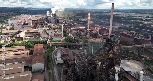 Aerial view of steel fabrication factory with blast furnace and smoke coming out of chimneys photo