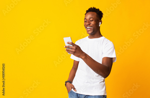 Hey there. Young cheerful afro guy having video call on orange background, copy space