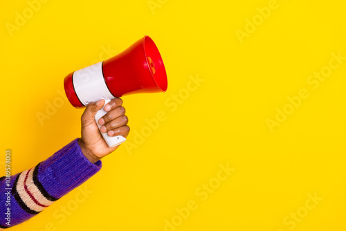 Cropped portrait of man hand hold loudspeaker empty space isolated on yellow color background