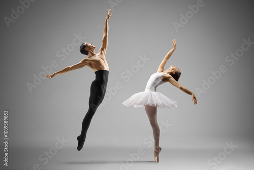 Man in black tights and woman in white tutu dress dancing ballet