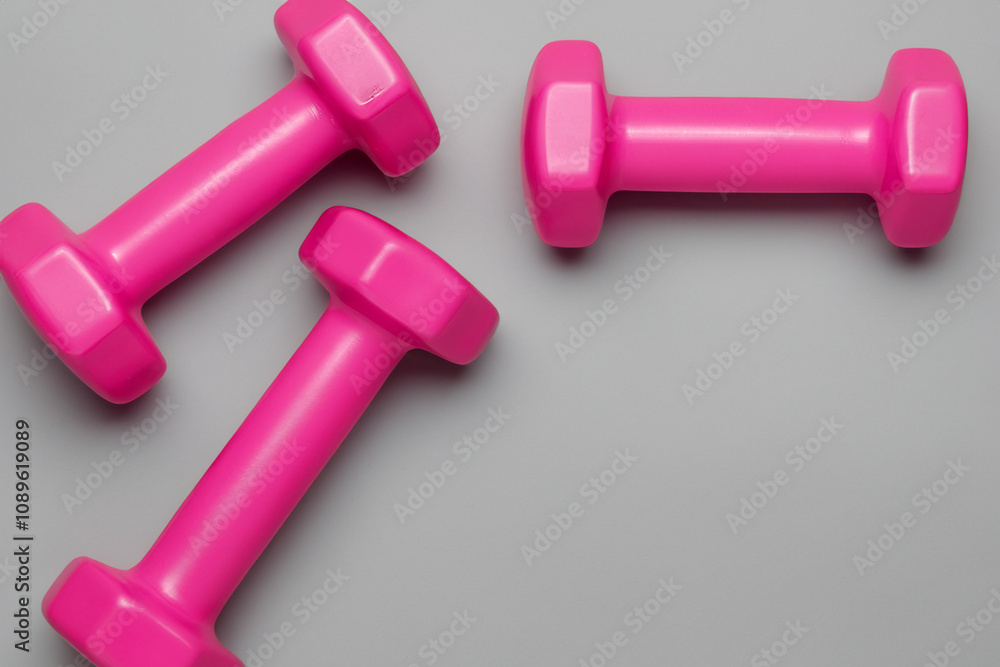 Pink dumbbells on a gray background. A gray background with pink weights. Pink weights gray background sport. Gray sport weights on a gray background lifestyle. Pink dumbbells on a gray background. A gray background with pink weights. Pink weights gray background sport. Gray sport weights on a gray background lifestyle.