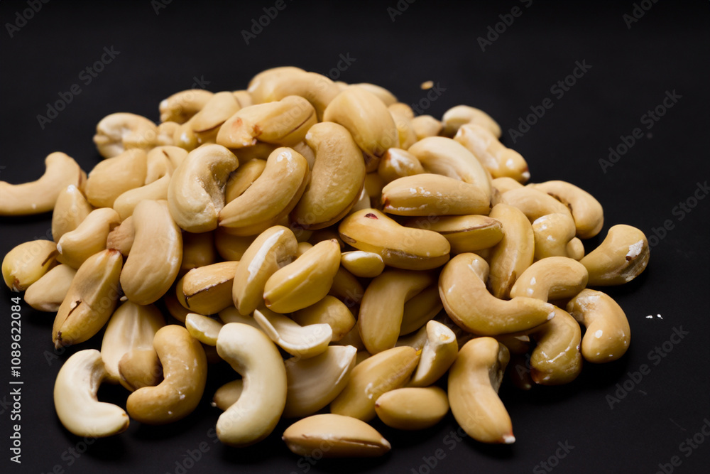 Cashew nuts on black background. Black almonds and nuts on a white background. Nuts almonds black background peeled almond nut handful lies. A handful of almonds lies on a black background lifestyle. Cashew nuts on black background. Black almonds and nuts on a white background. Nuts almonds black background peeled almond nut handful lies. A handful of almonds lies on a black background lifestyle.