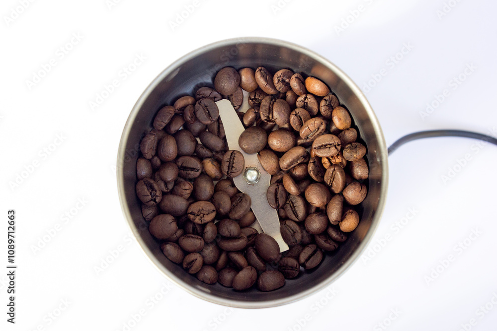 Fototapeta premium Coffee beans inside a coffee grinder machine background.