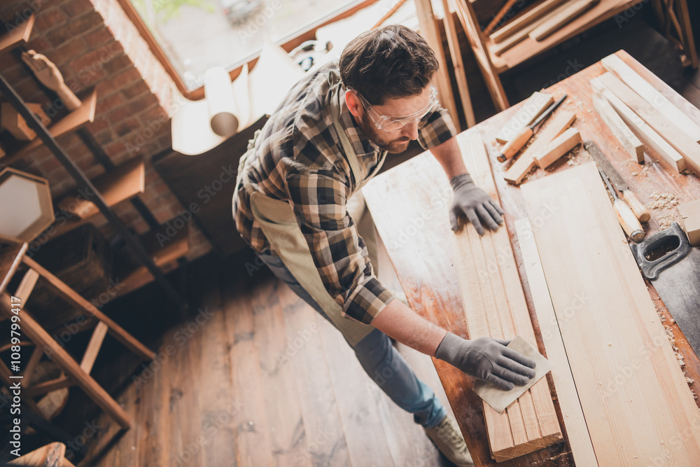 Fototapeta premium Top photo of builder workman guy focused working with wood plank on desk garage