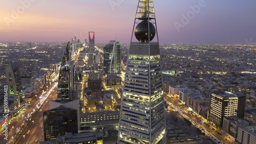 Al Faisaliah Tower pyramid-shaped commercial skyscraper. Riyadh. Drone shot flying. Sunset. Evening.