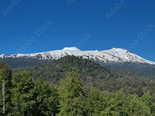 beautiful nature landscape with forest and mountain peaks with snow