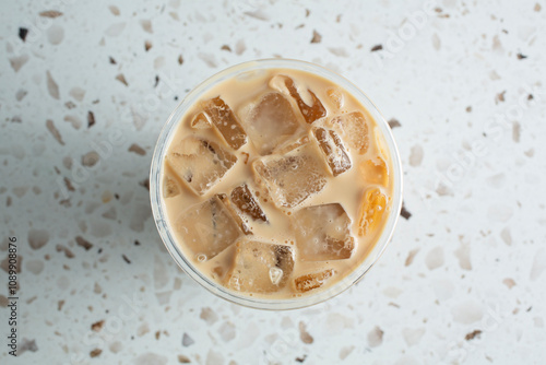 A top down view of a cup of iced chai latte.