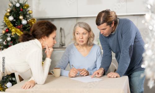 Adult married couple helps elderly woman make will testament, declaration for loan, application for settlement in nursing home during winter holiday photo