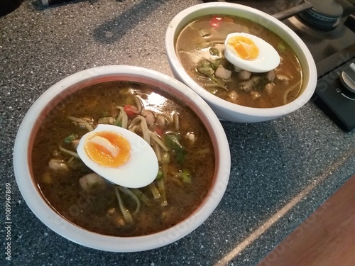 thai noodle soup with a half boiled egg on top