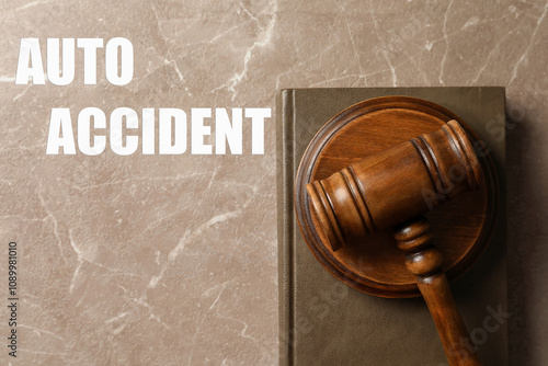 Auto accident law. Wooden judge's gavel and book on marble table, top view photo