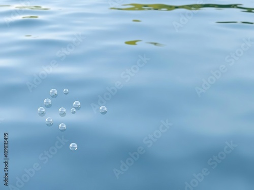 Bubbles floating on the surface of calm lake water, still water, reflective surface