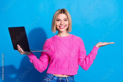 Photo of pretty young woman hold empty space laptop wear pink pullover isolated on blue color background