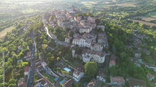 Drone aerial view in France countryside small old medieval brick town on a mountain top surrounded by green fields vertical panning on a sunny day in Cordes Sur Ciel photo