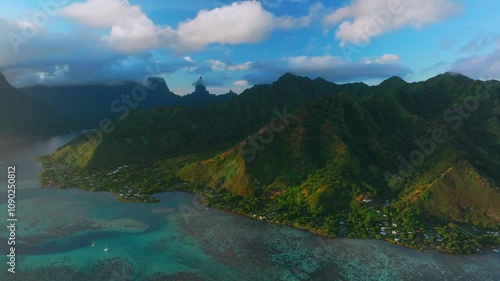 Golden hour sunset Cooks Opunohu Bay Moorea island French Polynesia aerial drone clouds covering Mount Mauaroa Tohivea Rotui clouds sailboats lagoon coral reef waves Pacific Ocean circle right photo