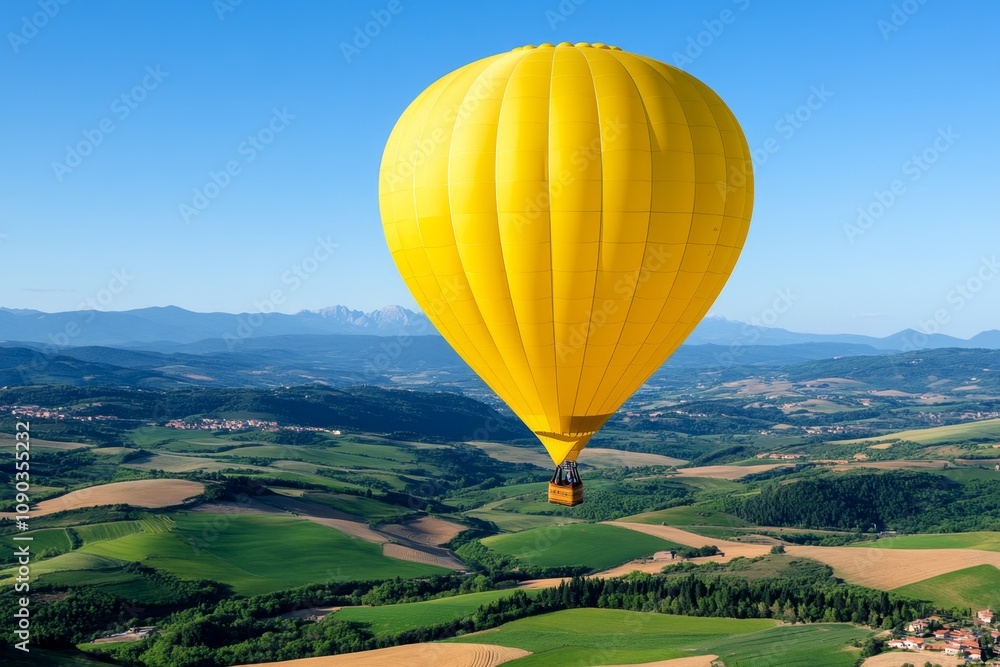 Naklejka premium Balloon air gliding over a patchwork of colorful farmlands, with the horizon stretching far and wide