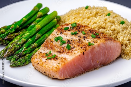 Tuna ahi fillet cooked rare, accompanied by a side of roasted garlic asparagus and quinoa photo