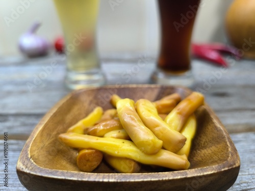 delicious pieces of Chechil cheese on a wooden plate, glasses of beer in the background photo