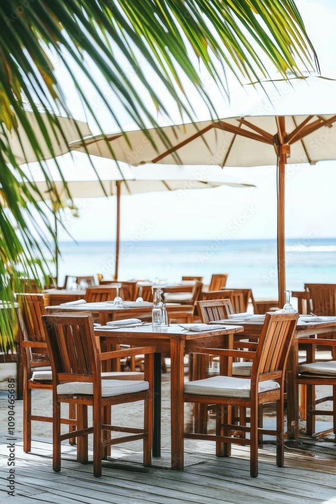 Fototapeta premium Beachfront restaurant with wooden tables and chairs.