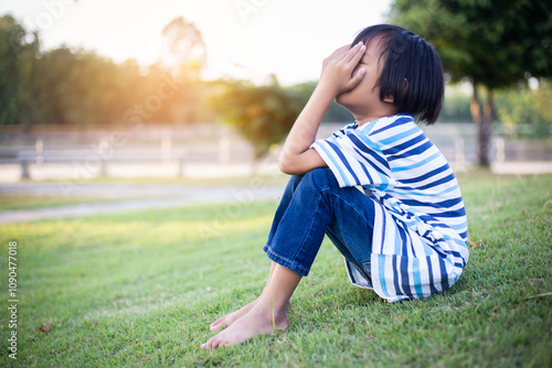 A sad little girl sitting alone outside photo