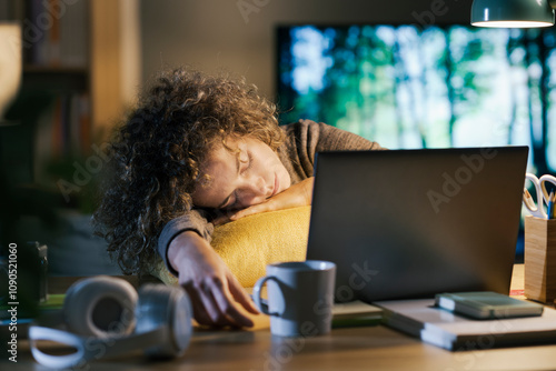 Woman falling asleep in front of the laptop photo