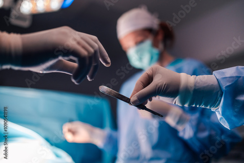 Obraz na plátně Scalpel handoff between medical professionals in operating room