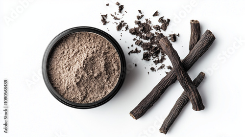 A bowl of licorice powder accompanied by dried licorice roots and crumbled pieces arranged on a clean white background. photo