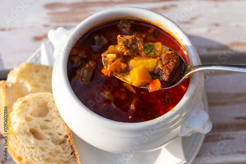 Obraz na płótnie Traditional Hungarian food. Beef goulash soup. Travel to Budapest for its cuisine. Food photography of two bowls with beef goulash soup on a wooden table in a restaurant. w salonie