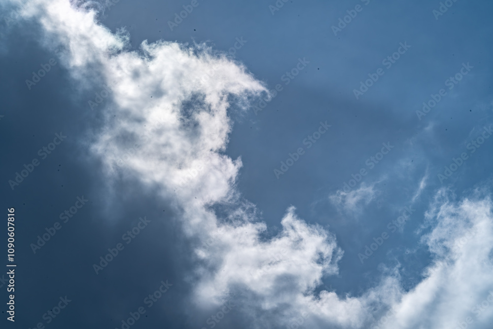 Fototapeta premium Dramatic cloudscape with fluffy cumulus clouds against a vibrant blue sky. This versatile image evokes feelings of freedom, peace, and possibility. 