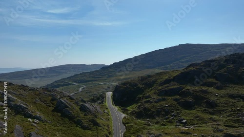 Healy Pass, County Cork, Ireland, September 2024. Drone pushes forwards following the road on the border with County Kerry revealing the mountain pass with boulder fields and rugged cliffs. photo