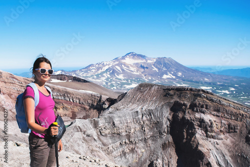 portrait of one girl tourist with backpack and hiking stick climbs volcano in Kamchatka, natural volcanic landscape, adventure and travel concept photo