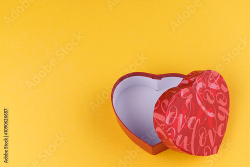 Valentine's Day gift, a red heart-shaped box on a yellow surface, captured in a top-down view, symbolizing love and romance photo