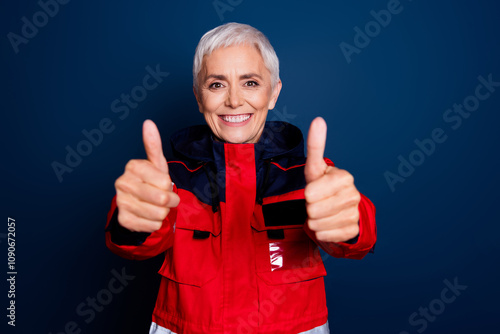 Photo of nice senior woman thumb up approve wear uniform paramedic doctor help isolated on dark blue color background photo