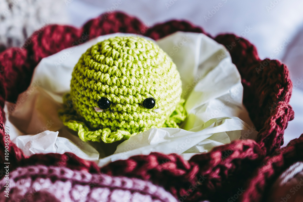 Atelier de crochet avec des travaux en cours, jouet petite pieuvre vert coloré en crochet