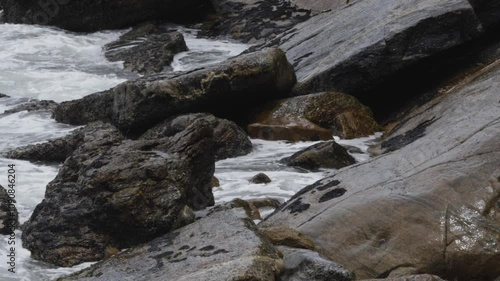 Foamy seas rage as waves crash on slippery rocks along the coastal beach of Maragogi in Alagoas, Brazil. photo