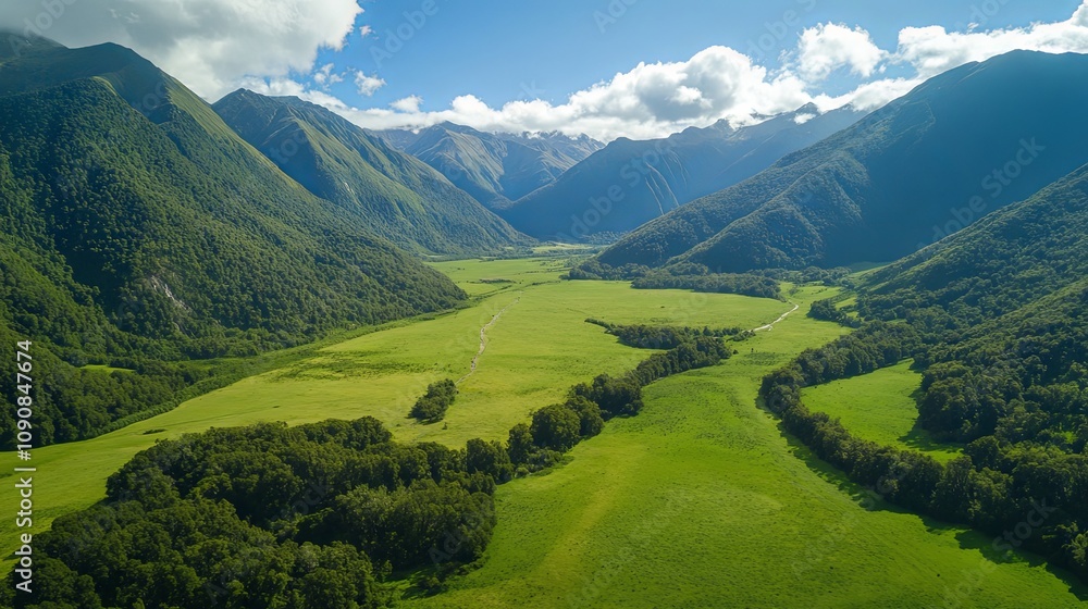 Fototapeta premium Aerial View of Lush Green Valley Surrounded by Majestic Mountains