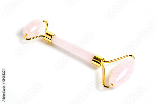 Pink Gua Sha massage tool over white background, close up focus stacking shot. Rose Quartz jade roller. Facial skin care at home, anti-aging and lifting therapy.