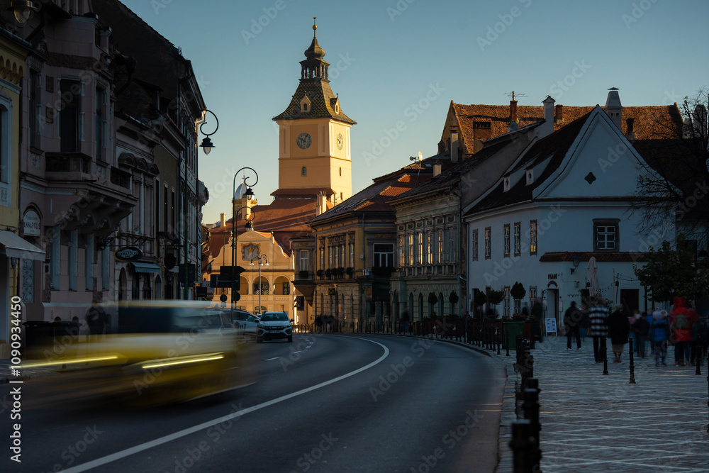 Obraz premium Brasov, Romania - October 22, 2024: Sunrise over Gheorghe Bariţiu Street in Brasov with Council Square in the Background. Long exposure shot.