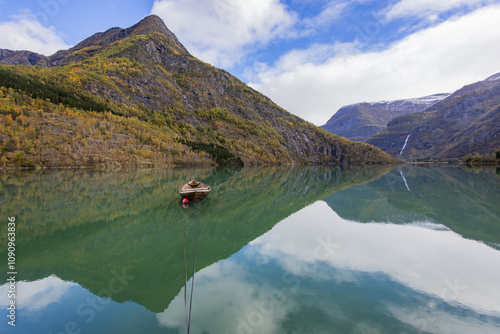 Autumn landscape in Skjolden, South Norway, with a calm lake reflecting the mountains and colorful foliage. photo