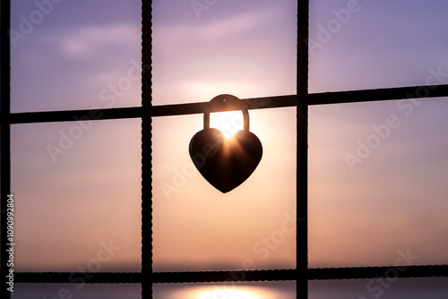 Silhouette of a heart-shaped lock catching the sunrise, symbolizing love and connection