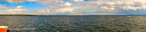 Stormy sky over a lake. Dark clouds with rays of sunshine that make the water sparkle photo